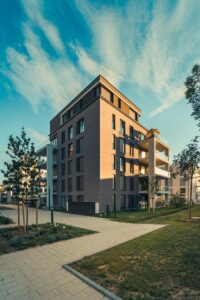 Contemporary apartment building exterior with landscaped surroundings under a clear sky.