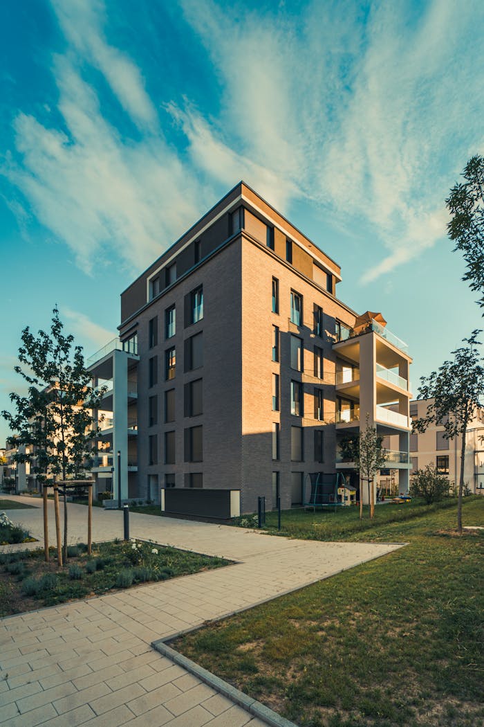 Contemporary apartment building exterior with landscaped surroundings under a clear sky.
