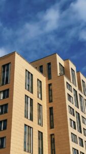 Stylish urban apartment building under a bright blue sky, perfect for architectural themes.